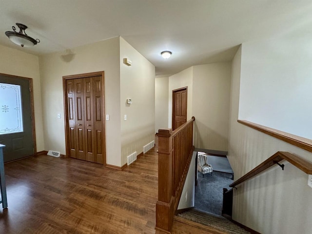 entryway with baseboards, visible vents, and dark wood-type flooring