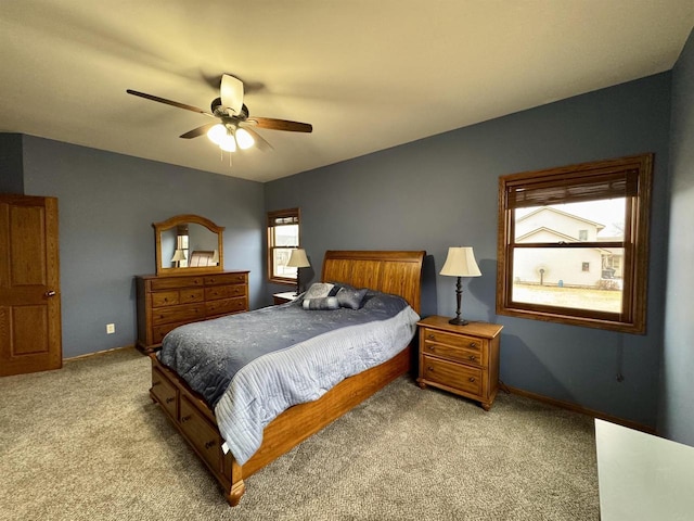 bedroom featuring light colored carpet, ceiling fan, and baseboards