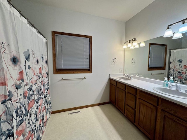 full bathroom featuring double vanity, a sink, visible vents, and baseboards