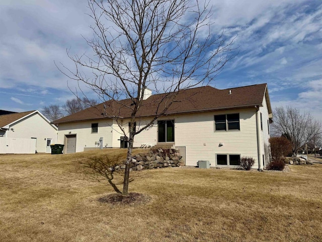 back of property with central AC and a yard