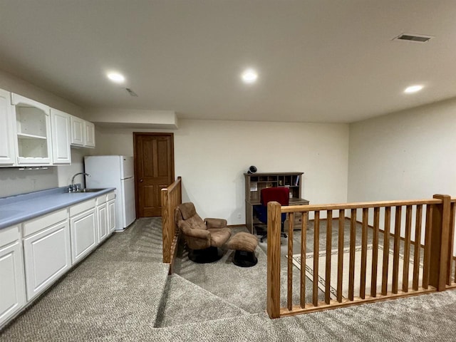 kitchen featuring recessed lighting, light colored carpet, visible vents, freestanding refrigerator, and white cabinets