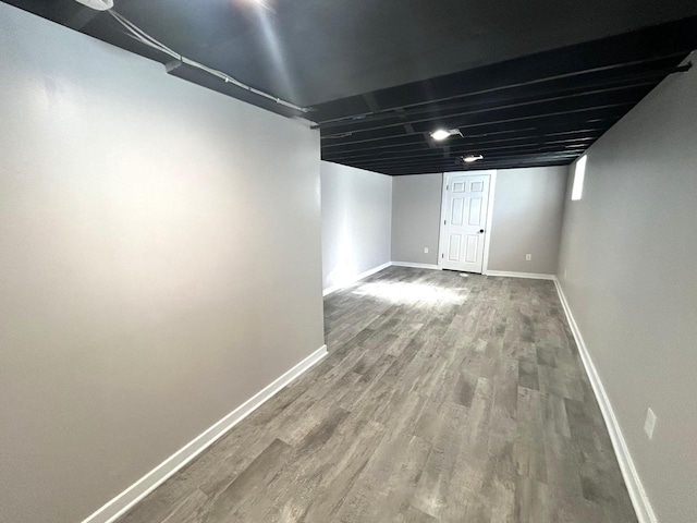 finished below grade area featuring baseboards and wood finished floors