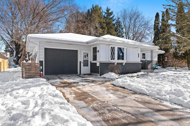 view of front of home featuring brick siding, driveway, and an attached garage