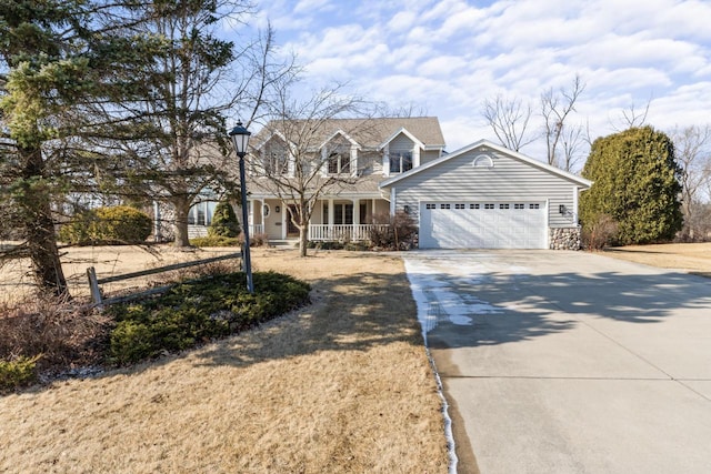 new england style home featuring covered porch, driveway, and an attached garage