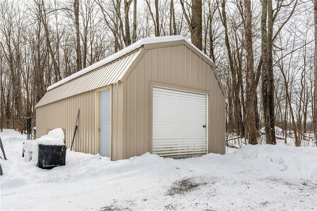 snow covered garage with a garage