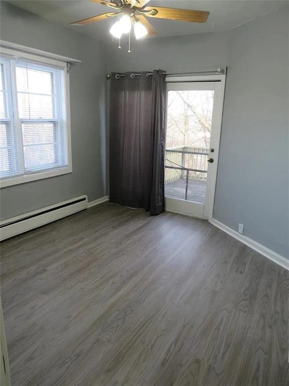 unfurnished room with plenty of natural light, baseboards, and wood finished floors