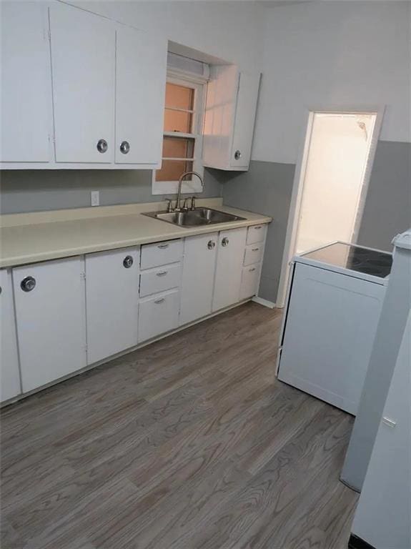 kitchen featuring light countertops, white cabinets, and a sink