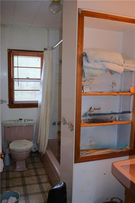 bathroom featuring tile patterned floors, toilet, and shower / tub combo with curtain