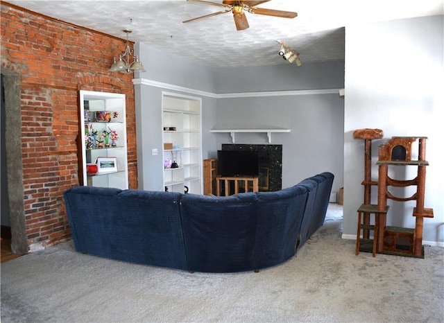 living area with carpet, a fireplace, and a ceiling fan