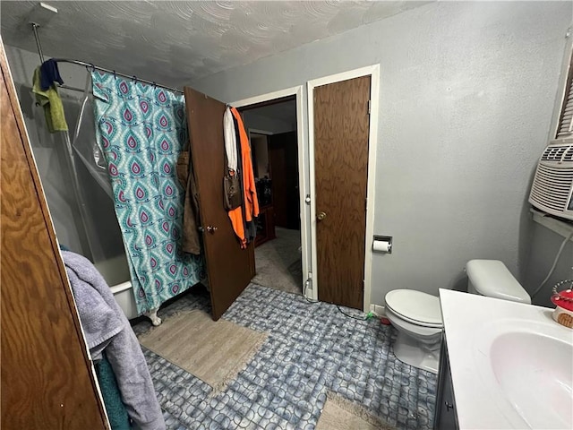 bathroom featuring toilet, a textured ceiling, shower / bath combination with curtain, and vanity