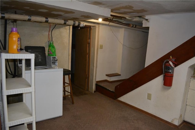 unfinished below grade area with dark carpet and washer and clothes dryer