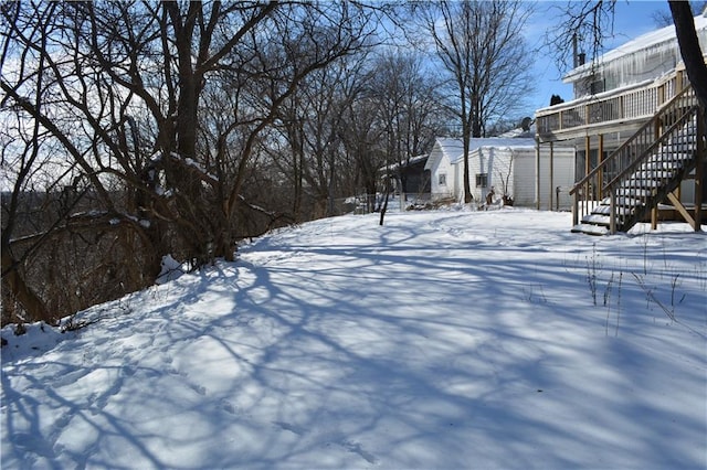 yard covered in snow with a garage and stairs