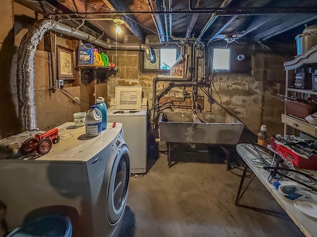 washroom featuring a sink, laundry area, and washing machine and clothes dryer