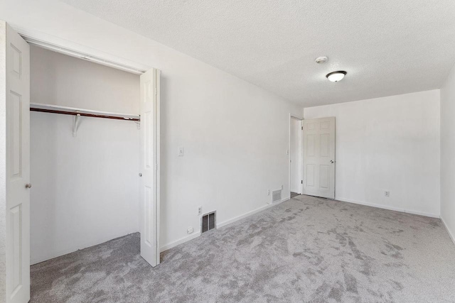 unfurnished bedroom featuring carpet flooring, visible vents, and a closet