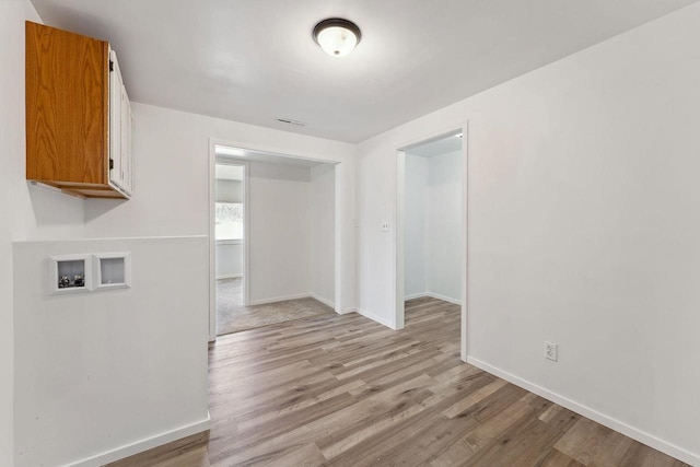 interior space with visible vents, light wood-type flooring, and baseboards