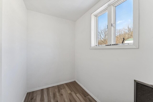 spare room featuring wood finished floors and baseboards