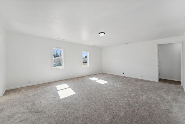 carpeted empty room with baseboards