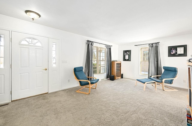 sitting room with baseboards, a healthy amount of sunlight, and carpet flooring