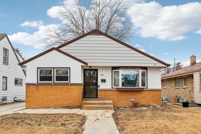 bungalow-style house featuring board and batten siding and brick siding