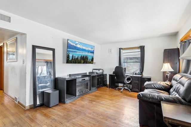 home office with light wood-style floors, baseboards, and visible vents