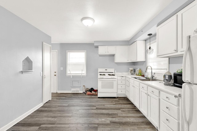 kitchen with pendant lighting, light countertops, white cabinets, a sink, and white appliances