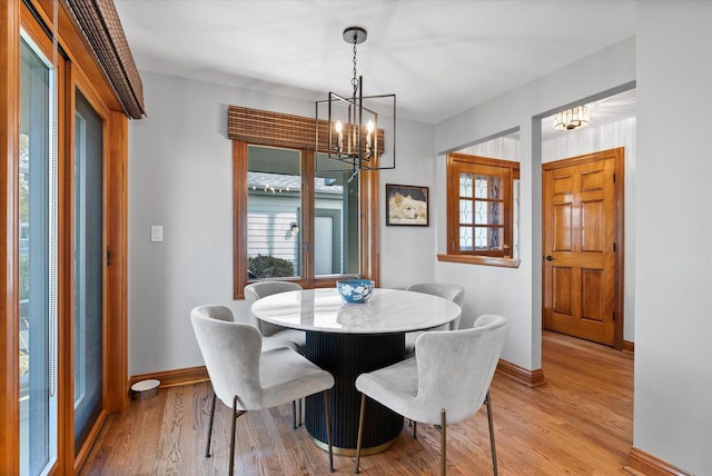 dining room featuring light wood finished floors, a wealth of natural light, and baseboards