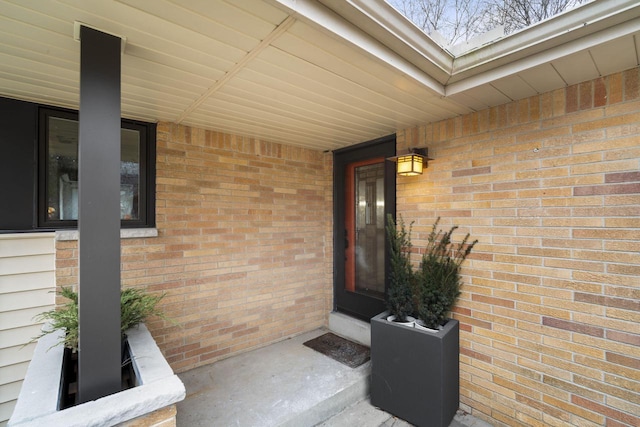 view of exterior entry featuring brick siding