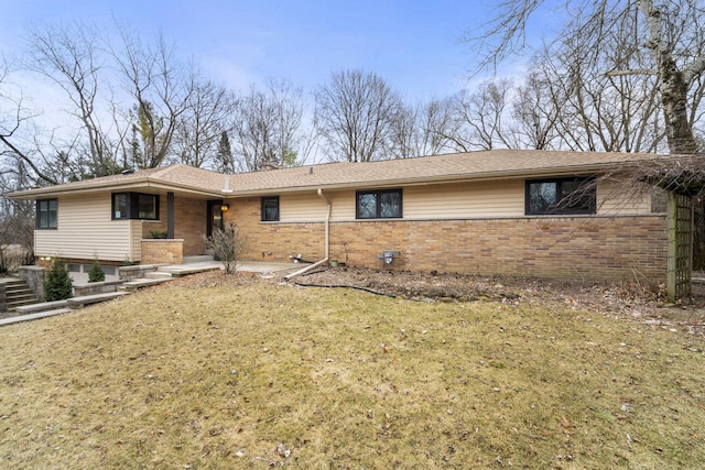 single story home with brick siding, a shingled roof, and a front lawn