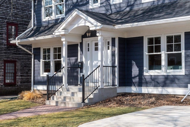 doorway to property featuring a shingled roof