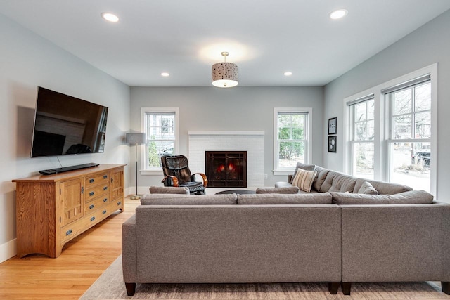 living room with light wood finished floors, a fireplace, and recessed lighting