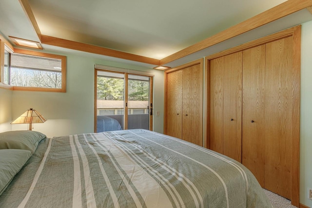 bedroom featuring access to exterior and two closets