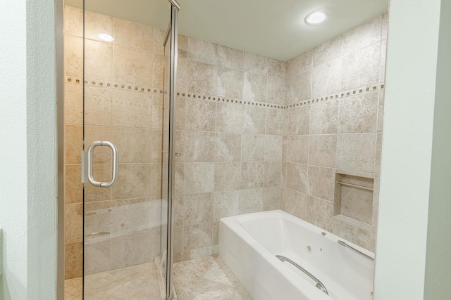 bathroom featuring tile patterned flooring, a garden tub, and a shower stall