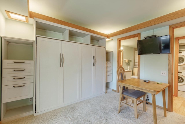 interior space featuring light carpet and stacked washer and dryer