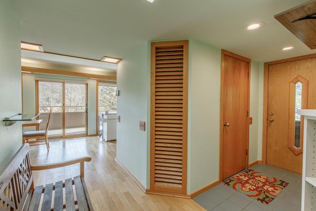 hall featuring light wood-type flooring, baseboards, and recessed lighting