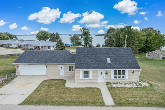 view of front of house with roof with shingles, an attached garage, a front yard, a patio area, and driveway