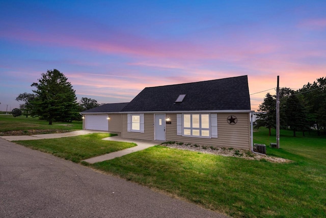 view of front facade with driveway, a shingled roof, a garage, and a front yard