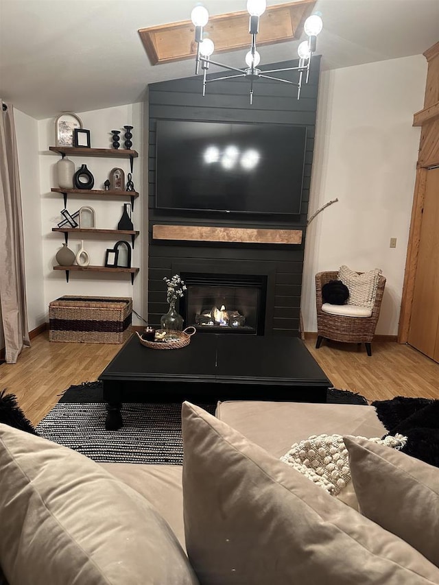 living room featuring light wood-style floors, a large fireplace, and vaulted ceiling