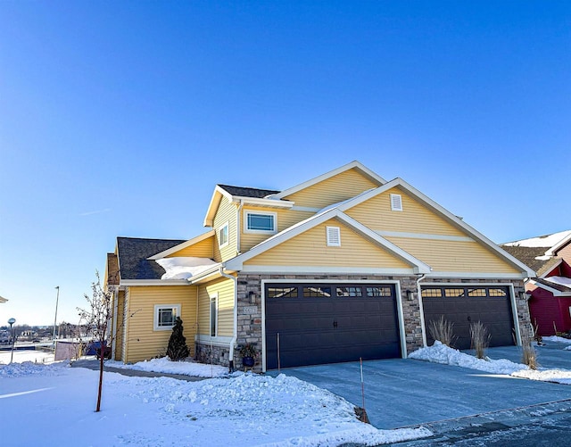 view of front of house featuring stone siding and driveway