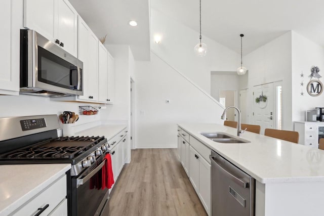 kitchen with stainless steel appliances, decorative light fixtures, and white cabinets