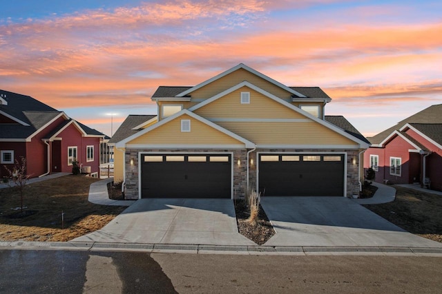 view of front of property with a garage, stone siding, and driveway