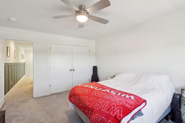 bedroom featuring a ceiling fan, a closet, and light carpet