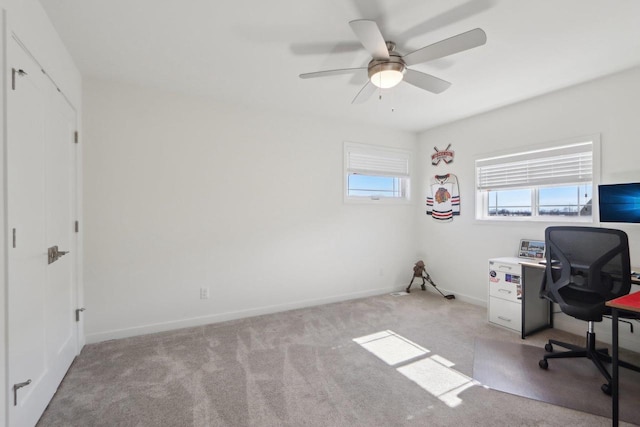 office space featuring a ceiling fan, light carpet, and baseboards