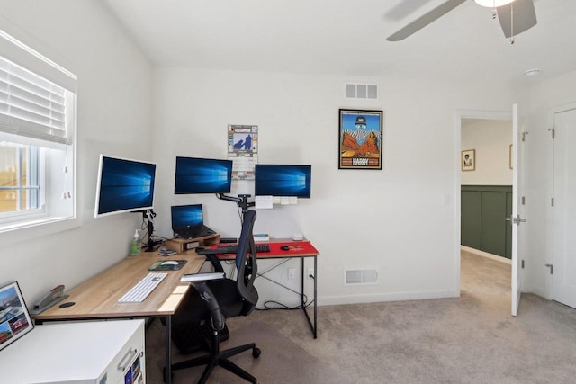 home office featuring a ceiling fan, visible vents, and light carpet