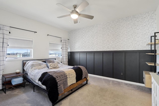 bedroom with carpet floors, wainscoting, a ceiling fan, and wallpapered walls