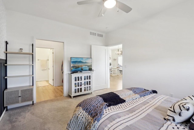 bedroom with ceiling fan with notable chandelier, lofted ceiling, visible vents, and light colored carpet