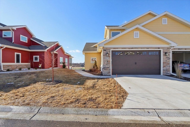 craftsman-style home with a garage, stone siding, and concrete driveway