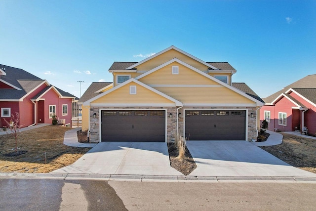 craftsman-style home featuring stone siding, a residential view, concrete driveway, and a garage