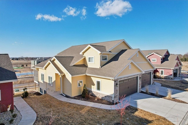 craftsman inspired home with an attached garage, a shingled roof, driveway, stone siding, and a residential view