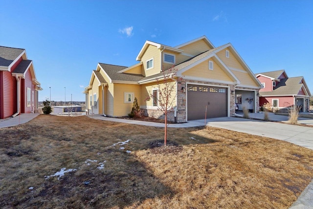 craftsman-style home featuring stone siding, an attached garage, and concrete driveway