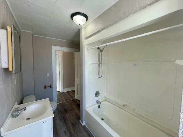 bathroom with toilet, wood finished floors, bathtub / shower combination, and vanity